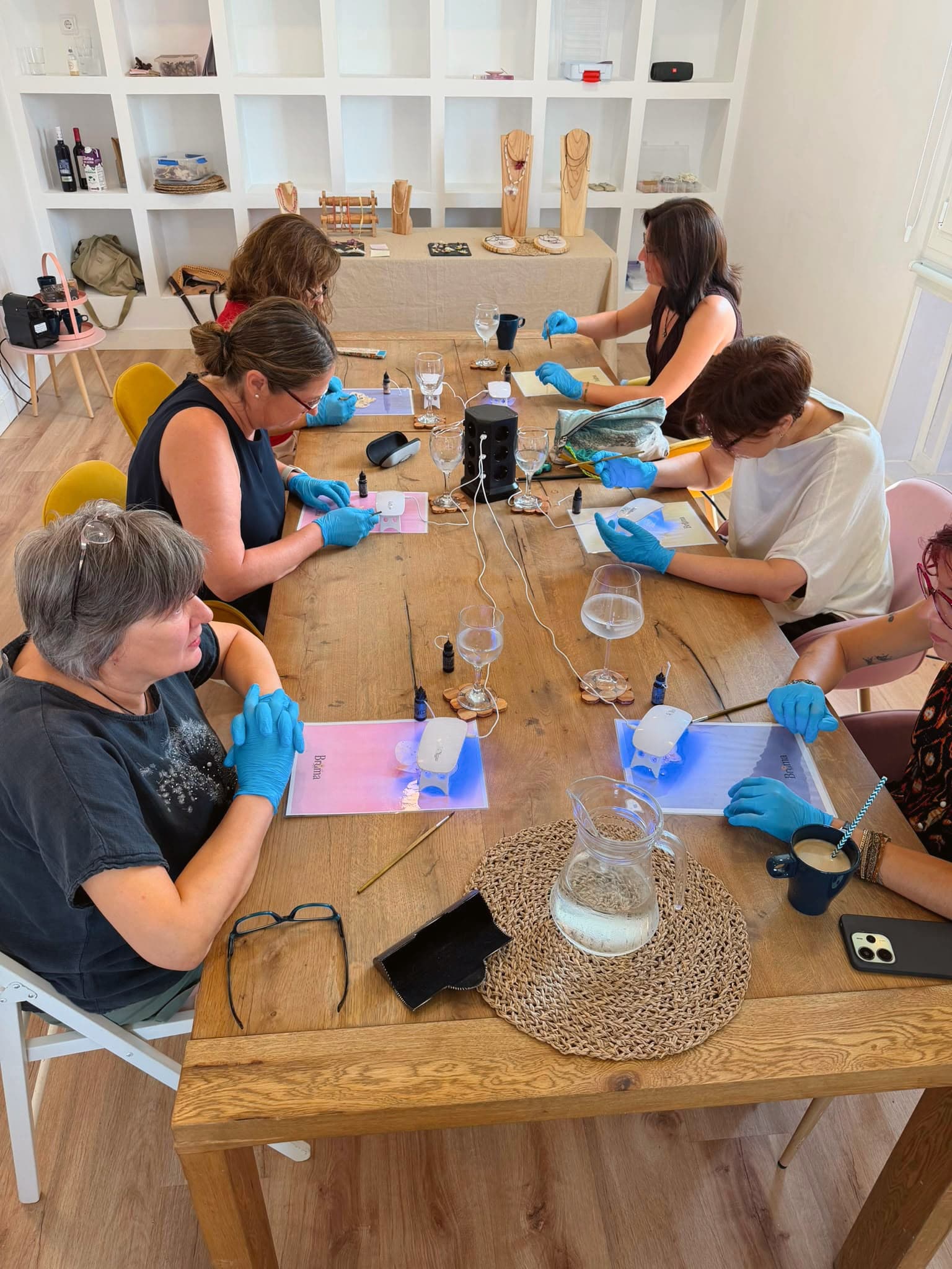 Grupo trabajando en sus piezas con guantes, con copas de vino sobre la mesa